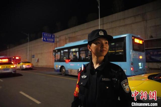 图为夜晚黄欣正在维持东兴市站出站口交通秩序。陈大鹏 摄