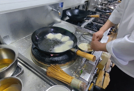 将锅包肉放入锅中炸第一遍。石洪宇 摄