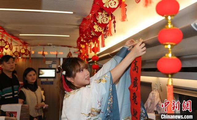 图为工作人员在高铁车厢内贴春联。卢键 摄