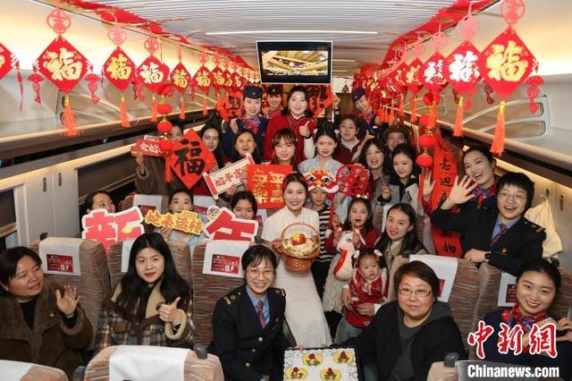 图为工作人员与乘客在高铁车厢内共庆北方小年。卢键 摄