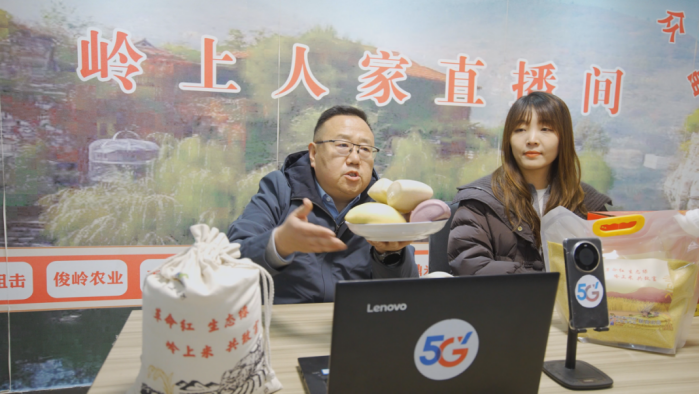 图为牛继林化身主播在岭上人家直播间推介小米等特色农产品。