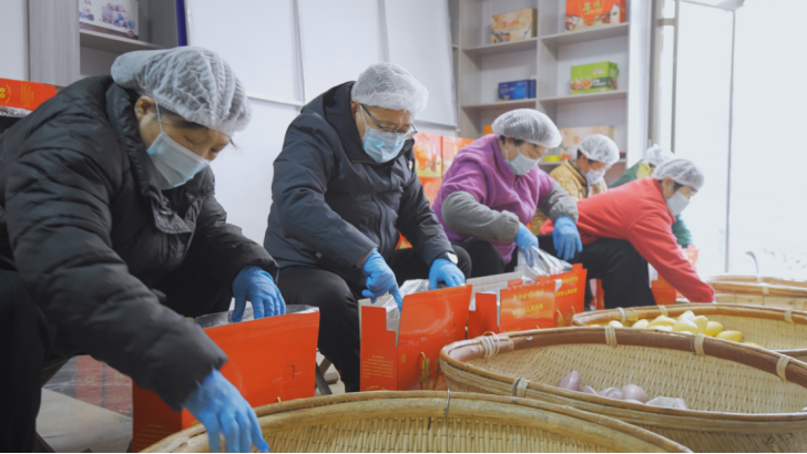 图为牛继林与村民一起打包春节放心馒头。