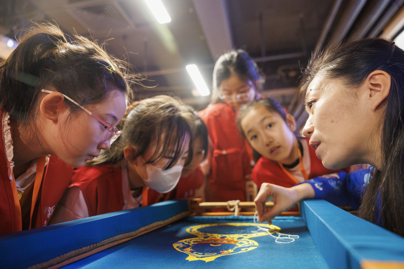 小记者们近距离围观，何洪杰边绣边讲解要点。新京报记者 王子诚 摄