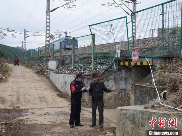 图为韦东在修建的交通涵前给黄辉老人做安全宣传。姚鹏鹏 摄