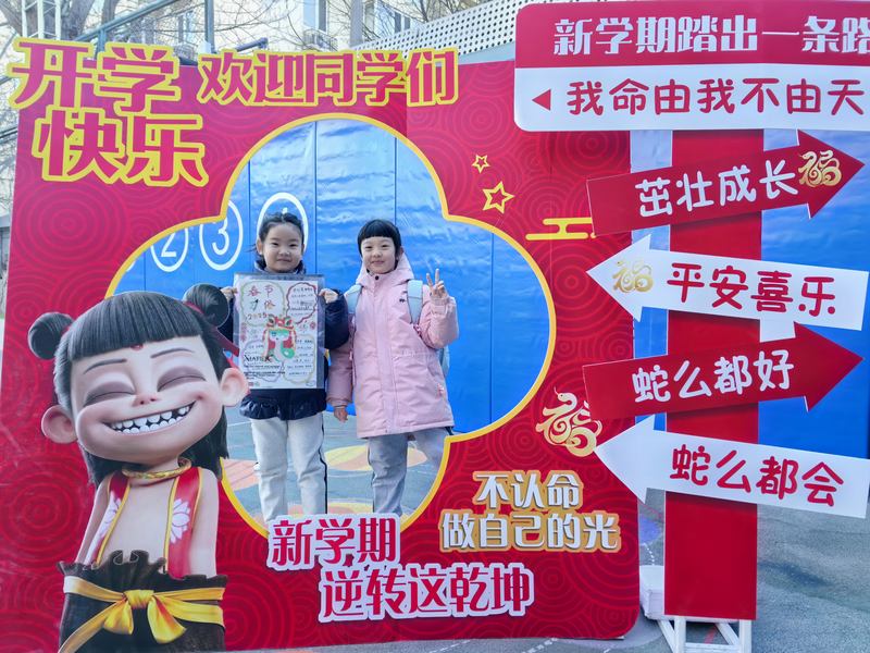 学生们跟哪吒主题背景板合影。新京报记者 杨菲菲 摄