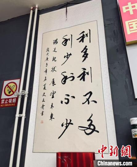 2月12日，李文华店面内的墙上，挂着一幅写有“利多利不多，利少利不少”的书法作品。 付中华 摄