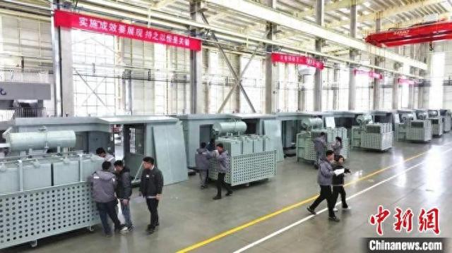在企業(ye) 生產(chan) 車間內(nei) ，工人們(men) 正在組裝設備。王夢君 攝