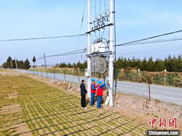 国网翼城县供电公司中卫供电所党员服务队两名队员“全副武装”，检查农排线路和设备。 王航 摄