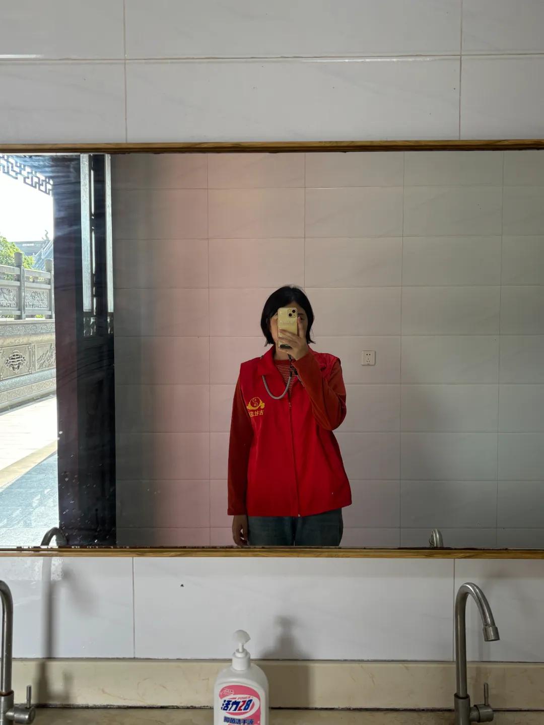 米亚做义工时，穿着道观发的红色马甲。（图/受访者提供）