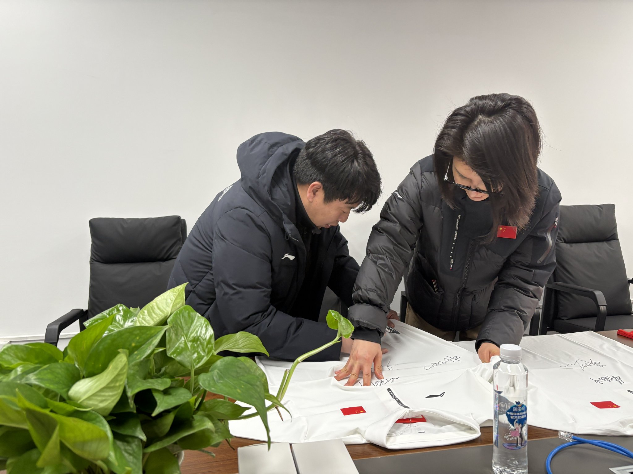 杜丽和庞伟在运动服上留下签名。