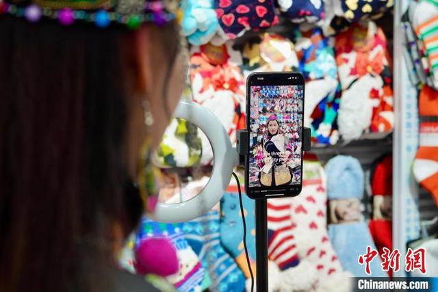 2月25日，浙江义乌专售袜子的老板傅江燕查看自己用AI生成的带货视频。 董易鑫 摄