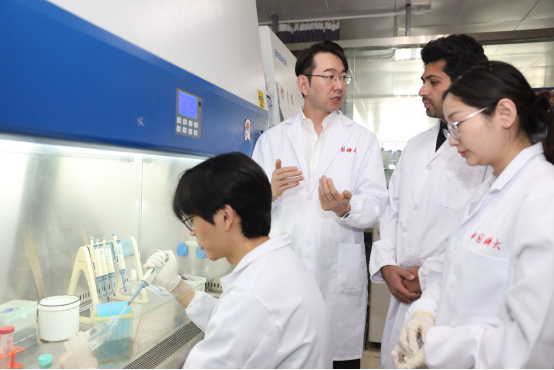 孙成教授（左二）指导学生进行实验。中国科大供图