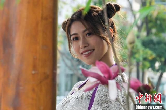 图为造像摄影活动上，一位女士与花朵合影。中新网记者 陈永诺 摄