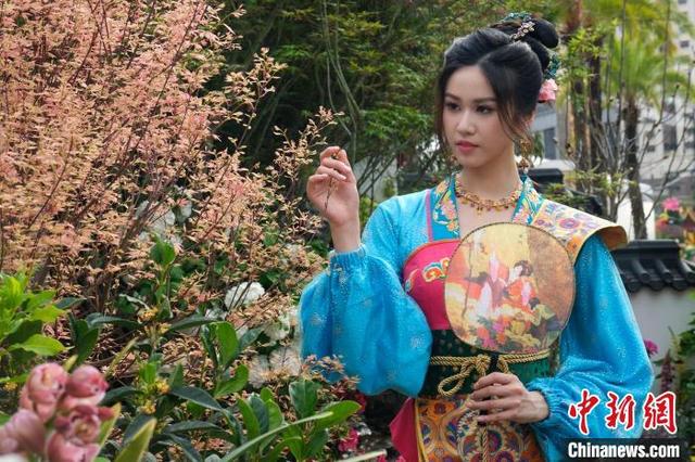图为造像摄影活动上，一位女士与花朵合影。中新网记者 陈永诺 摄
