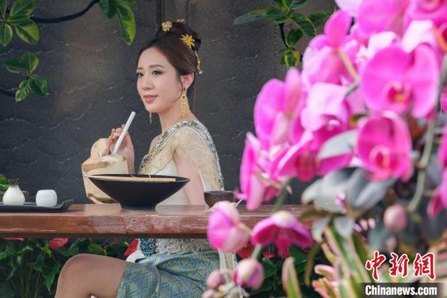 图为造像摄影活动上，一位女士与花朵合影。中新网记者 陈永诺 摄