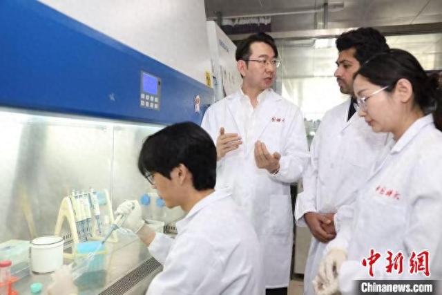 中国科大孙成(左二)指导学生进行实验。中国科大 供图