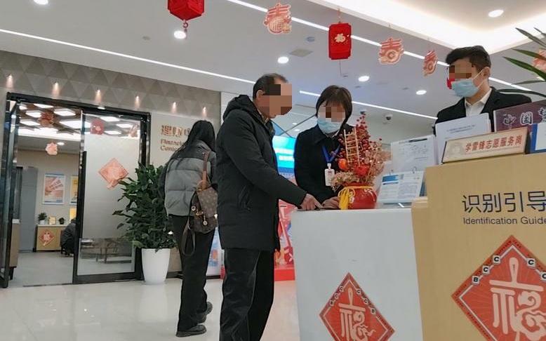▲2月20日，建行武汉长江新区支行，此时在前台接待储户的两人都是信泰人寿保险公司的销售人员。新京报记者 韩福涛 摄