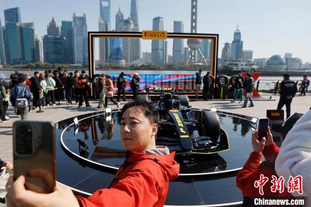 3月17日，市民与F1赛车模型合影。中新社记者 殷立勤 摄