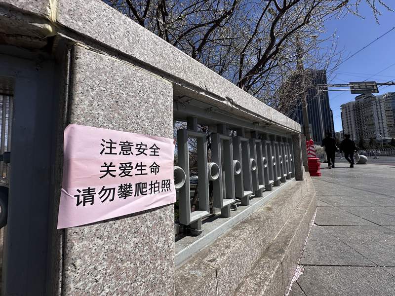 阜成门桥护栏上，贴上了文字提示。新京报记者 裴剑飞 摄