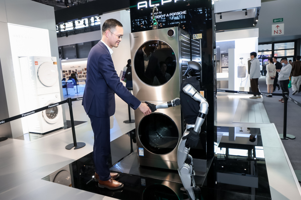 宇树机器人现身松下展台两者互动。