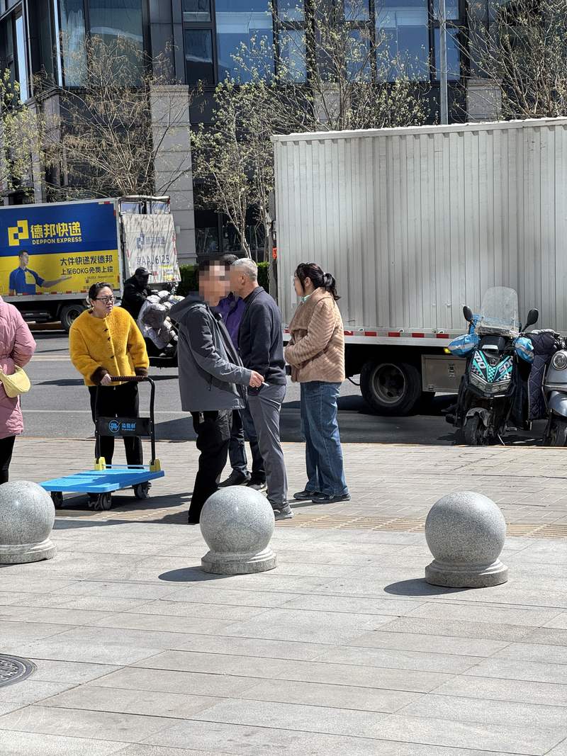 3月29日下午，有人在汇琴购物中心2号门前抽烟。新京报记者 王景曦 摄