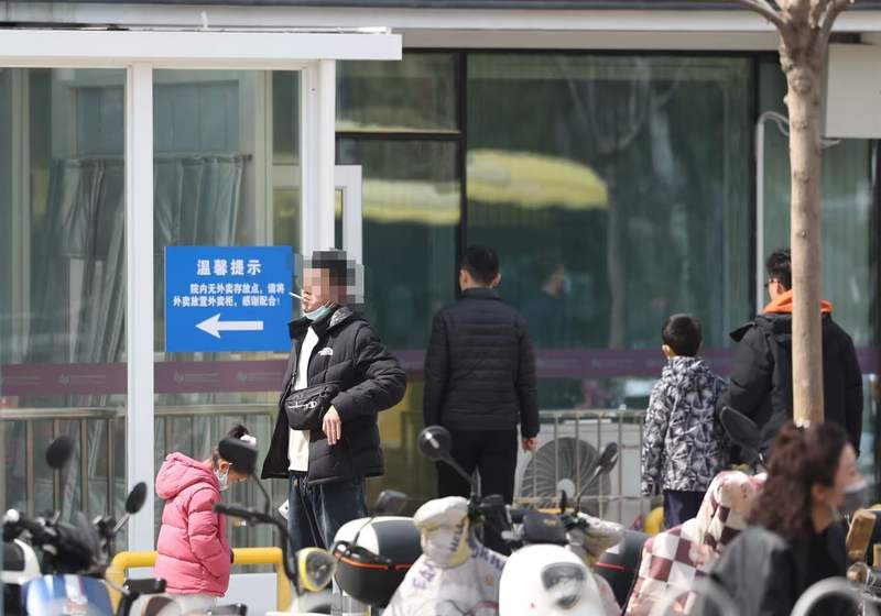 3月28日下午，儿研所外，市民在马路上吸烟。新京报记者 王飞 摄