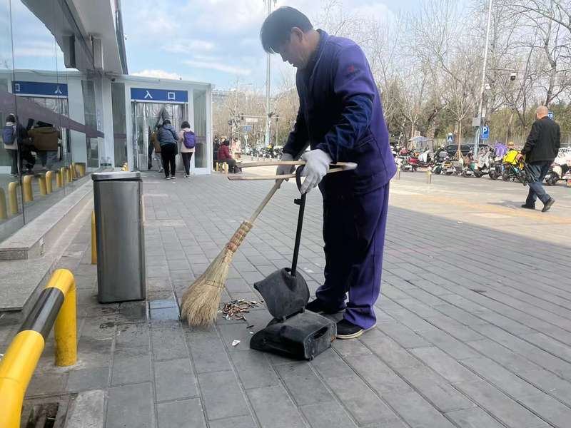 3月28日下午，儿研所东门外灭烟区，保洁员在清扫烟头。新京报记者 王飞 摄