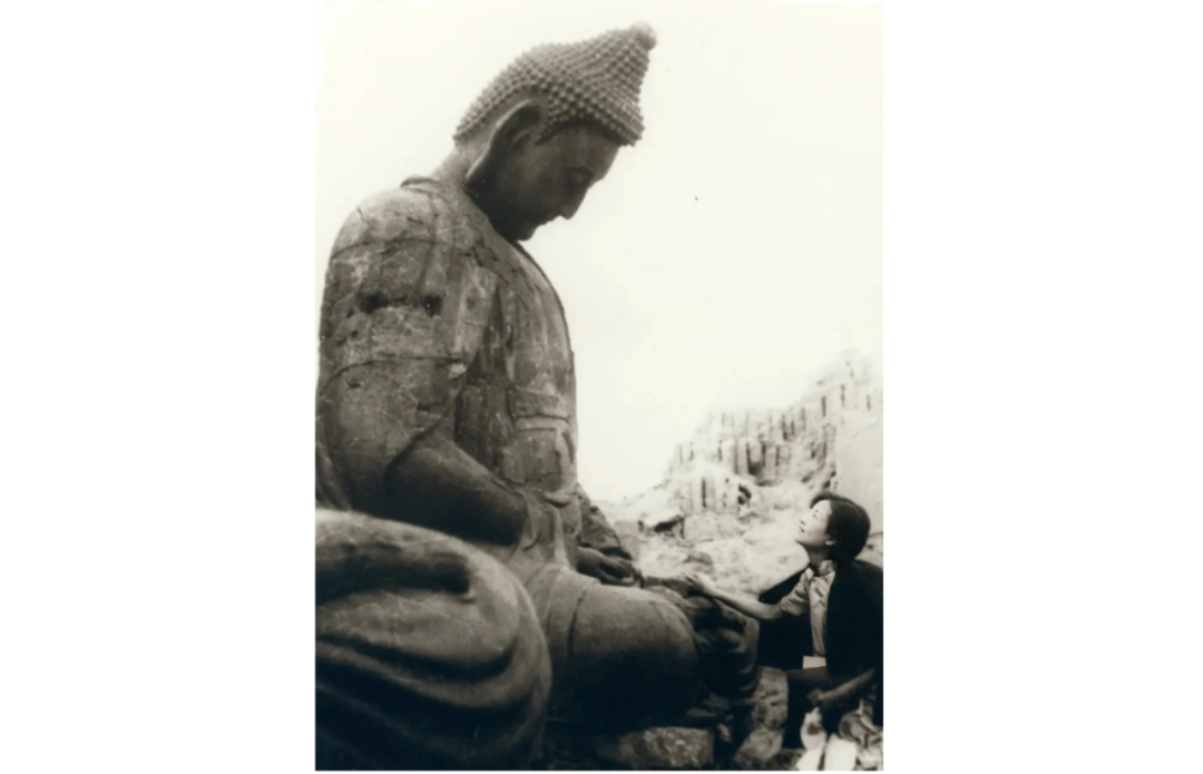 ▲1934年8月，山西汾州小相村灵岩寺废墟中，林徽因与铁佛无言的凝视。