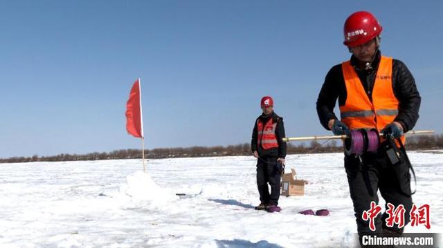 爆破人员在冰封的黑龙江江面上布线实施人工破冰作业。 苏宁 摄