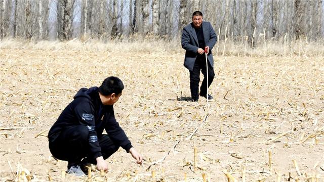 工作人员正在丈量土地。 李威 摄