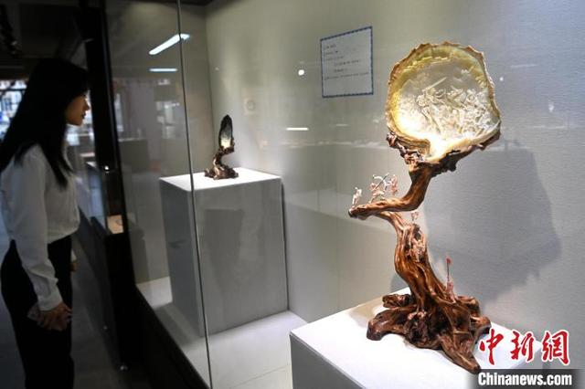 3月28日，参访者在福建省漳州市工艺美术馆参观翁清香贝雕展。中新网记者 张金川 摄