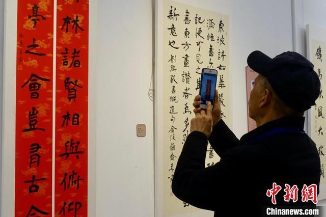4月1日，参观者拍摄书法作品。中新社记者 钱晨菲 摄