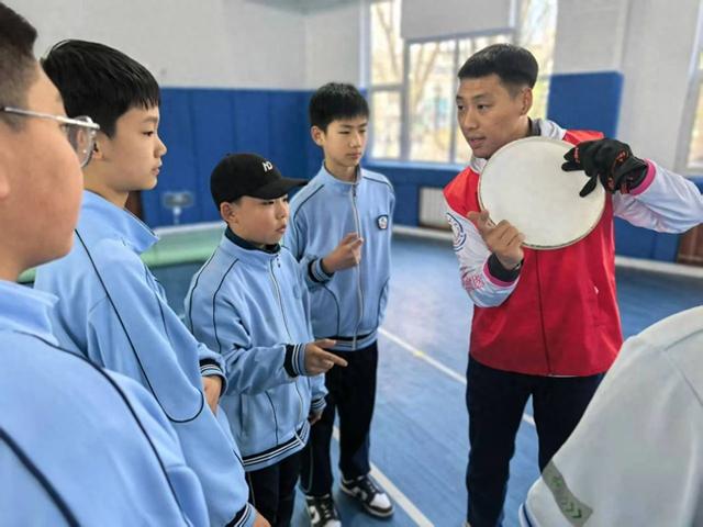 志愿者为学生讲解要领。（内蒙古体育局供图）