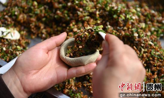 3月31日，松桃苗族自治县的人们在包清明粑。谢慧芳摄