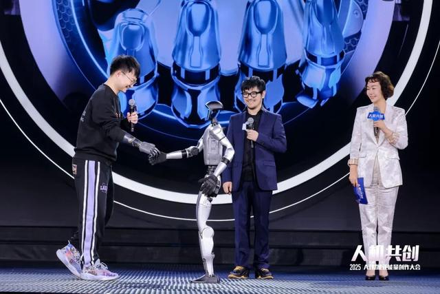 《2025中国·AI盛典》上,机器人与仿生手体验官握手。人民视频供图