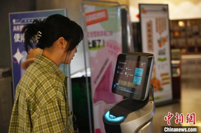 4月13日，位于甘肃省兰州市的甘肃简牍博物馆内，游客与AI机器人“小简”对话。中新社记者 李亚龙 摄