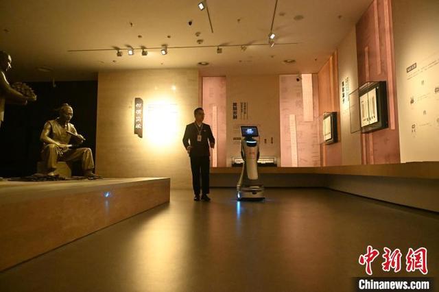 4月10日，位于甘肃省兰州市的甘肃简牍博物馆内，工作人员与AI机器人“小牍”在行进中交流沟通。中新社记者 李亚龙 摄