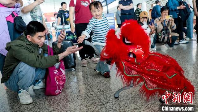 图为一位旅客与机器狗互动。中新社记者 张畅 摄