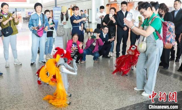 图为一位旅客与机器狗互动。中新社记者 张畅 摄