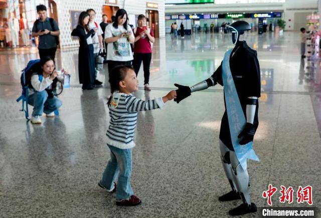 图为一位小朋友与人形机器人握手互动。中新社记者 张畅 摄