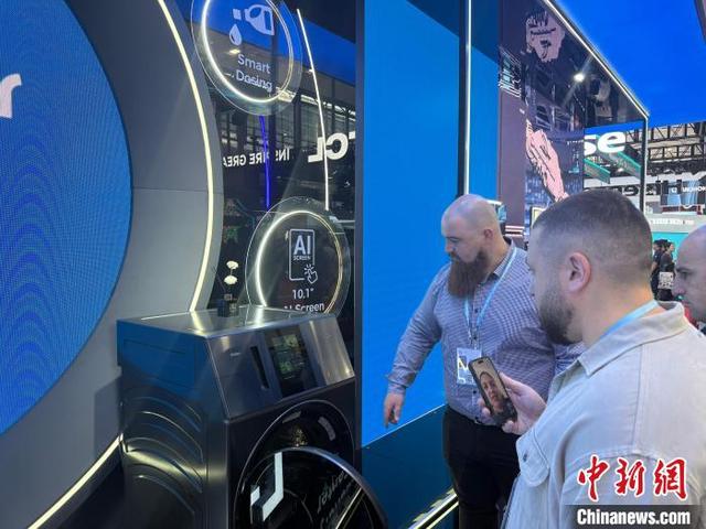 4月15日，境外采购商在广交会上尝试AI洗衣机性能。中新社记者 蔡敏婕 摄