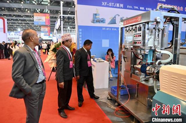 4月19日，福建晋江，外国客商参观了解制鞋机器。中新社记者 王东明 摄