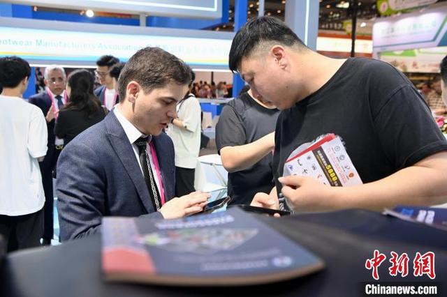 4月19日，福建晋江，外国客商与国内商家添加联系方式。中新社记者 王东明 摄