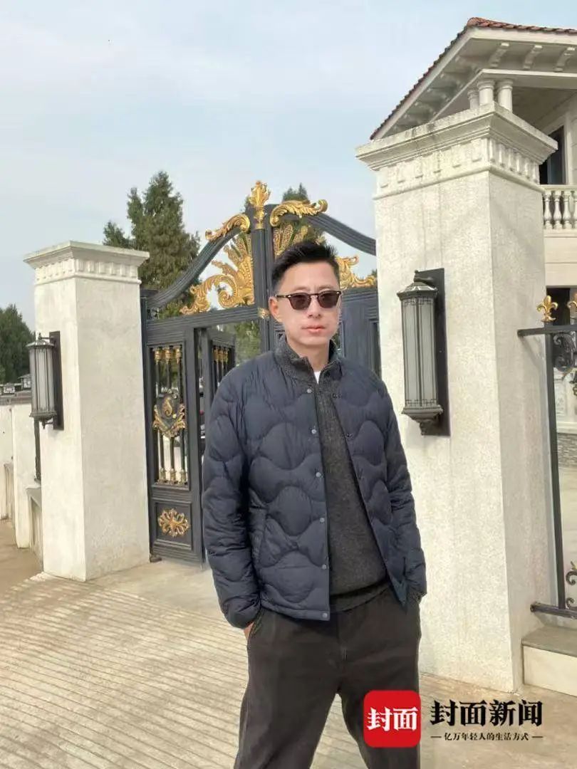 在老家新房前的何吉林。(受访者供图)