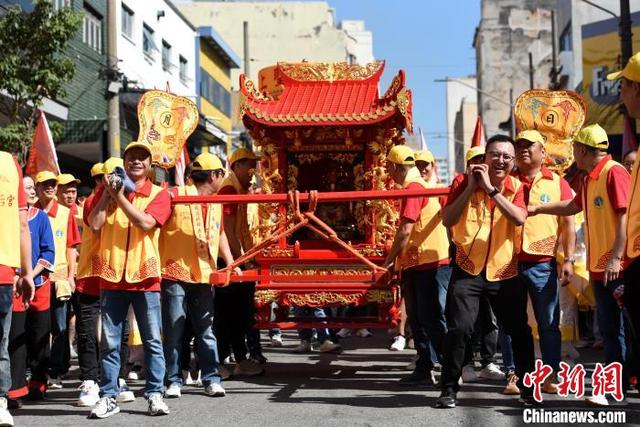 当地时间4月19日，巴西圣保罗，妈祖銮轿行至布拉斯商区，信众们依循古制颠轿、呐喊祈福。中新社记者 林春茵 摄