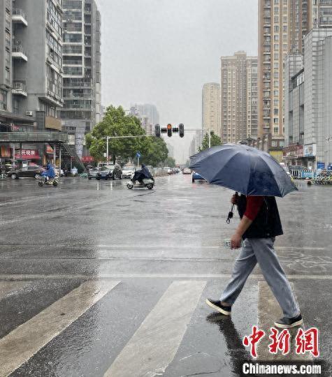 21日早晨，武汉市民冒雨出行。 马芙蓉 摄