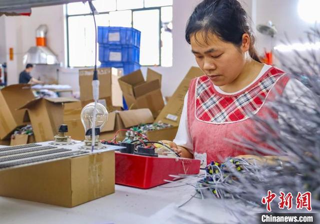 图为工人组装、检测电子产品。周火文 摄
