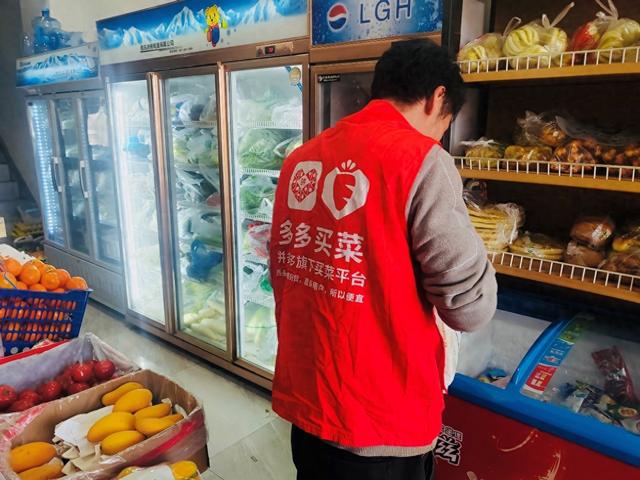 马龙将多多买菜海原县城一处提货团点的订单放置在便利店货架上。李康|摄