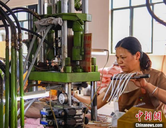图为工人组装、检测电子产品。周火文 摄