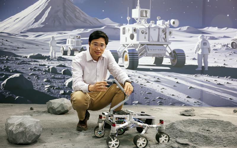 崔勇在依比例还原的月球表面场景上演示月球车。 新京报记者李木易 摄